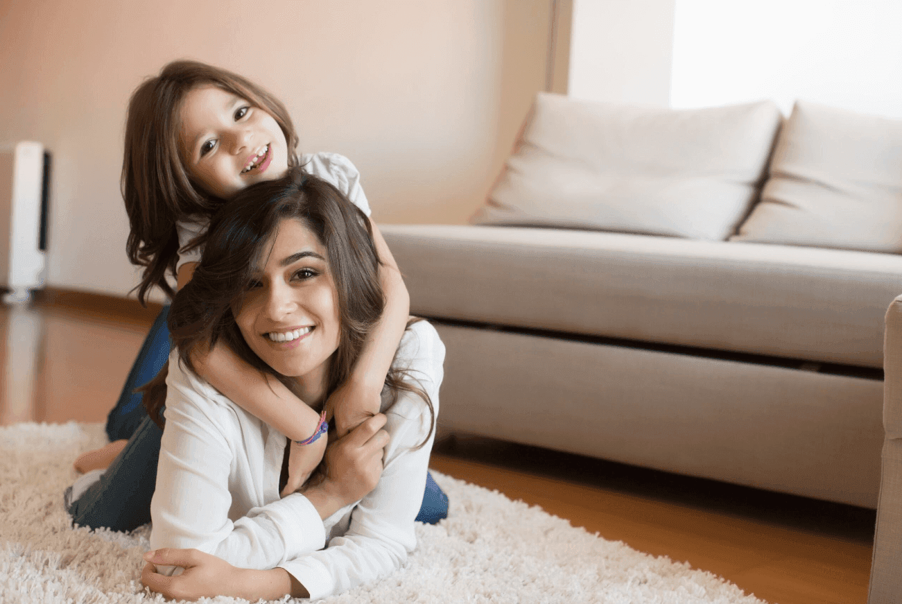 Mother and daughter smiling and lounging at home.